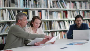 Mature students in library studying together