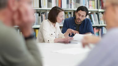 Mature students in library studying together