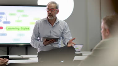 Close-up of teacher lecturing adult students