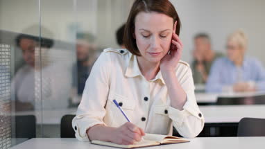 Senior student taking notes in a lecture