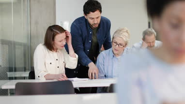 Teacher helping mature students on a course