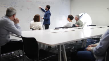 Teacher using white board in adult education course
