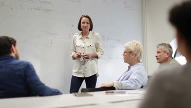 Teacher using white board in adult education course