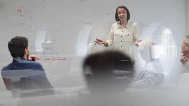 Teacher using white board in adult education course