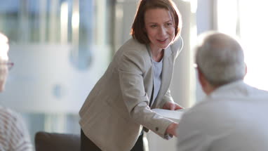 Senior couple shaking hands with financial advisor