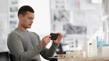 Architect taking photo of model in studio 