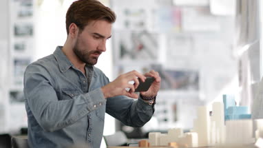 Architect taking photo of model in studio 