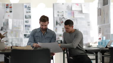 Designers looking at architectural plans in a creative workspace