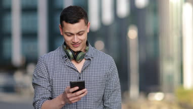 Young adult male with smartphone in city