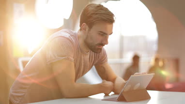Young adult male working on digital tablet