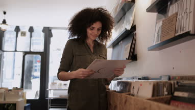 Young Adult female holding record in a store