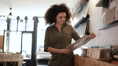Young Adult female holding record in a store