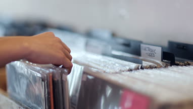Closeup of hands looking through records in a store