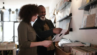Store owner helping customer in a record store