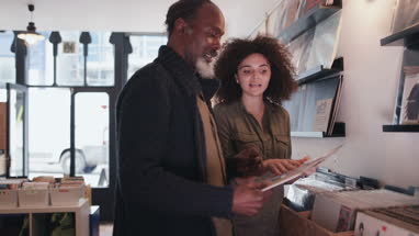 Store owner helping customer in a record store