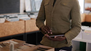 Portrait of small business owner using digital tablet in a record store