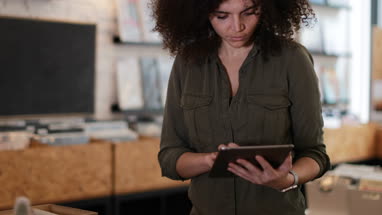 Portrait of small business owner using digital tablet in a record store