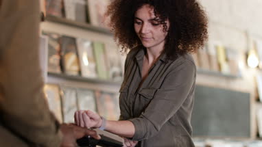 Customer making paying with smartwatch in a record store