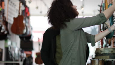 Small business owner helping customer in a guitar store
