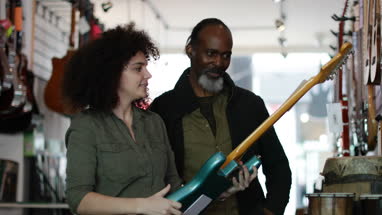 Small business owner helping customer in a guitar store