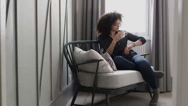 Young adult female looking at smartwatch at home