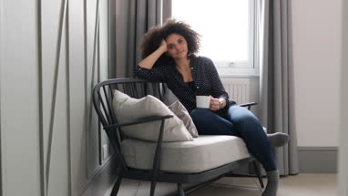 Portrait young adult female relaxing at home with coffee