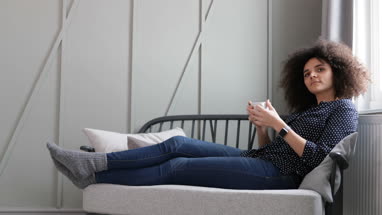 Young adult female relaxing at home with coffee