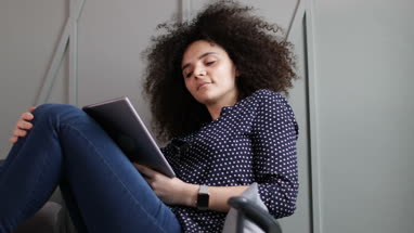 Young adult female using digital tablet at home