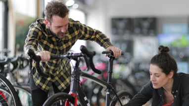 Small business owner helping customer in a bike store