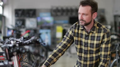 Adult male choosing a bike in a cycle store