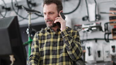 Small business owner on phone and computer in a store