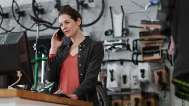 Small business owner on phone and computer in a store