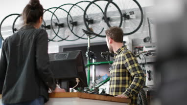 Small business owner serving customer in a bicycle store