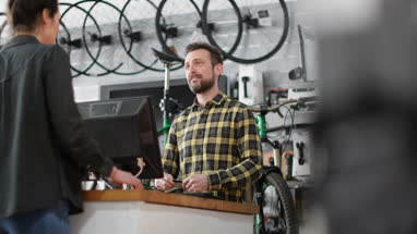 Small business owner serving customer in a bicycle store