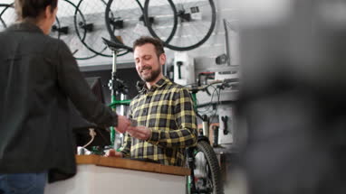 Small business owner serving customer in a bicycle store