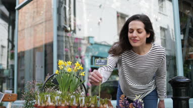 Florist pricing flowers and plants outside store