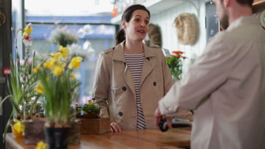 Adult female paying with credit card in a florist