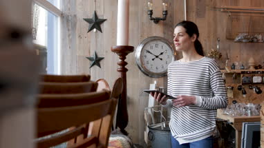Small business owner using digital tablet in a store