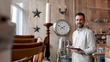 Portrait of small business owner holding digital tablet in a home store