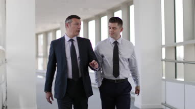 Businessmen walking through office having a meeting