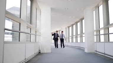 Businessmen walking through office having a meeting