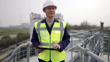 Closeup industrial worker using a digital tablet on site