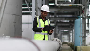 Female industrial worker checking pipeline