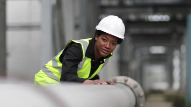 Female industrial worker checking pipeline