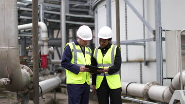 Female industrial worker being trained using a digital tablet on site