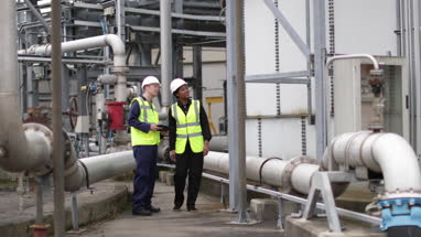 Female industrial worker being trained using a digital tablet on site