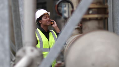 Female industrial worker using radio on site