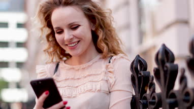 Young adult female looking at smartphone outdoors in city