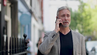 Mature male on smartphone in city