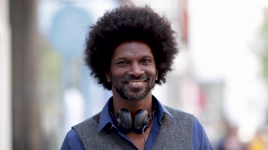 Portrait of happy African American male outdoors in city